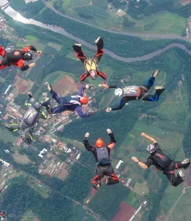 Seis paraquedistas fazendo uma formação no ar